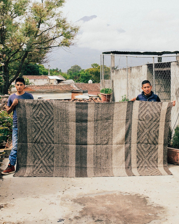 Jun Batz Artisans Showing off the Story of Source Striped Pepenado Rug 